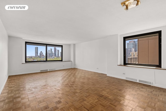 empty room with parquet floors and plenty of natural light