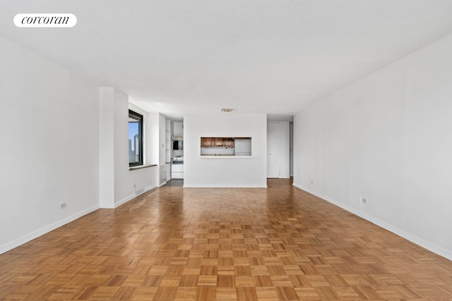 unfurnished living room with light parquet floors and a textured ceiling