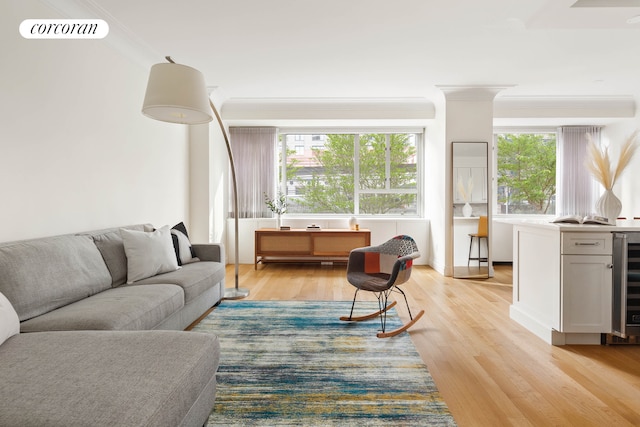 living room featuring a wealth of natural light, light hardwood / wood-style floors, and ornamental molding