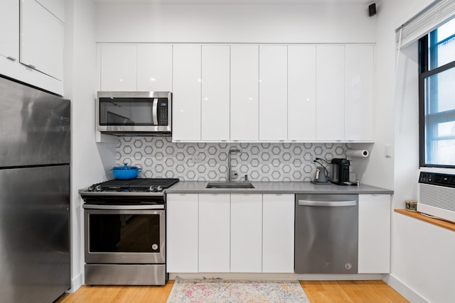 kitchen with a wealth of natural light, sink, appliances with stainless steel finishes, and white cabinetry