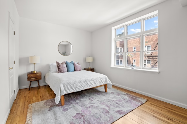 bedroom with multiple windows and light hardwood / wood-style flooring