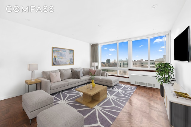 living room featuring radiator, expansive windows, and parquet floors