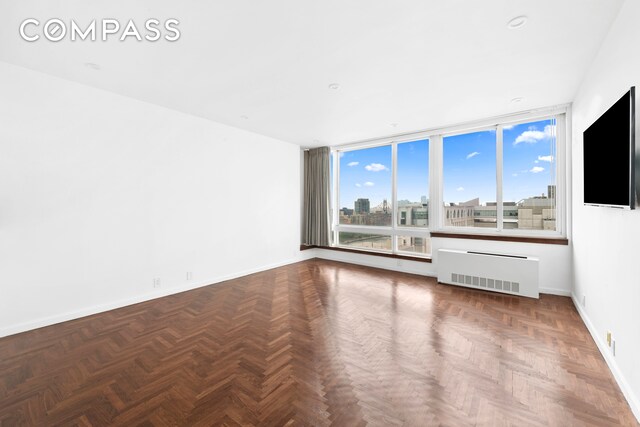 empty room featuring parquet floors and radiator