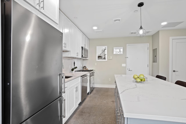 kitchen featuring light stone countertops, appliances with stainless steel finishes, pendant lighting, white cabinets, and a kitchen island