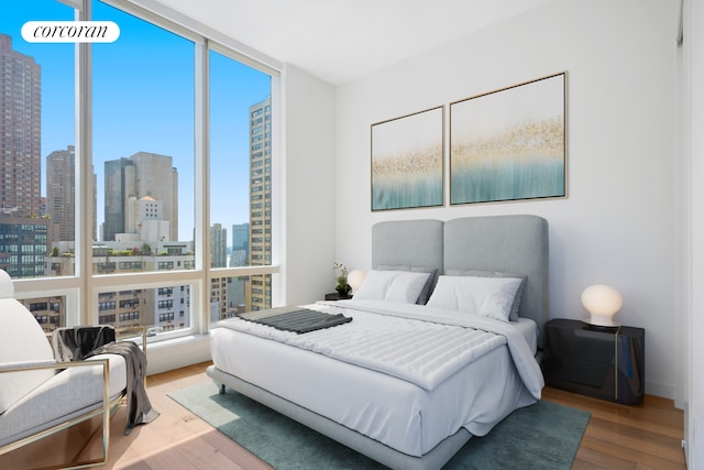 bedroom featuring hardwood / wood-style flooring and a wall of windows