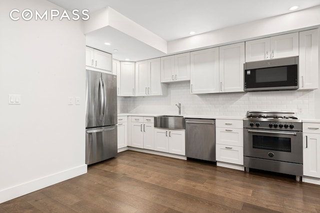 kitchen featuring stainless steel appliances, tasteful backsplash, sink, and dark wood-type flooring