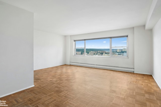 spare room with baseboard heating and light parquet flooring