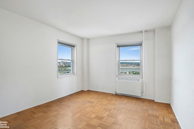 empty room with radiator and light parquet flooring