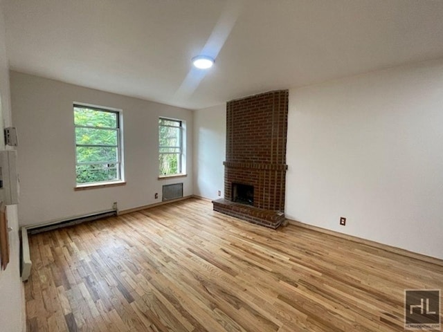 unfurnished living room featuring a fireplace, light hardwood / wood-style floors, and baseboard heating