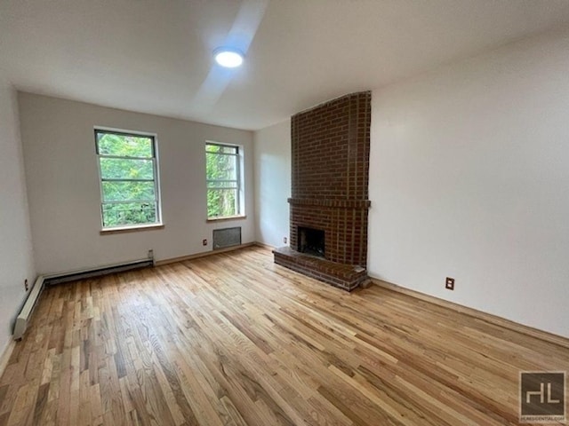 unfurnished living room featuring a fireplace, light hardwood / wood-style flooring, and baseboard heating