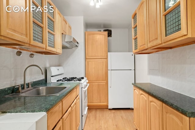 kitchen featuring wall chimney exhaust hood, tasteful backsplash, white appliances, and light hardwood / wood-style floors