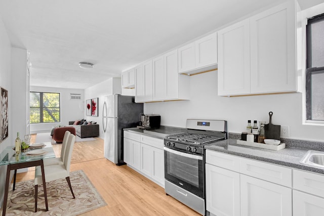 kitchen featuring sink, appliances with stainless steel finishes, white cabinets, and light wood-type flooring