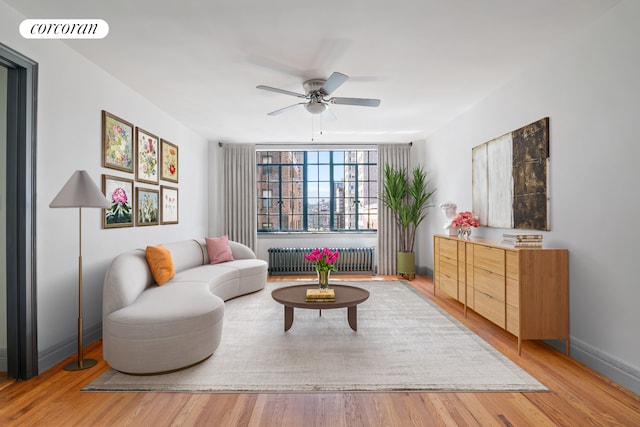 living room with light hardwood / wood-style flooring, radiator, and ceiling fan