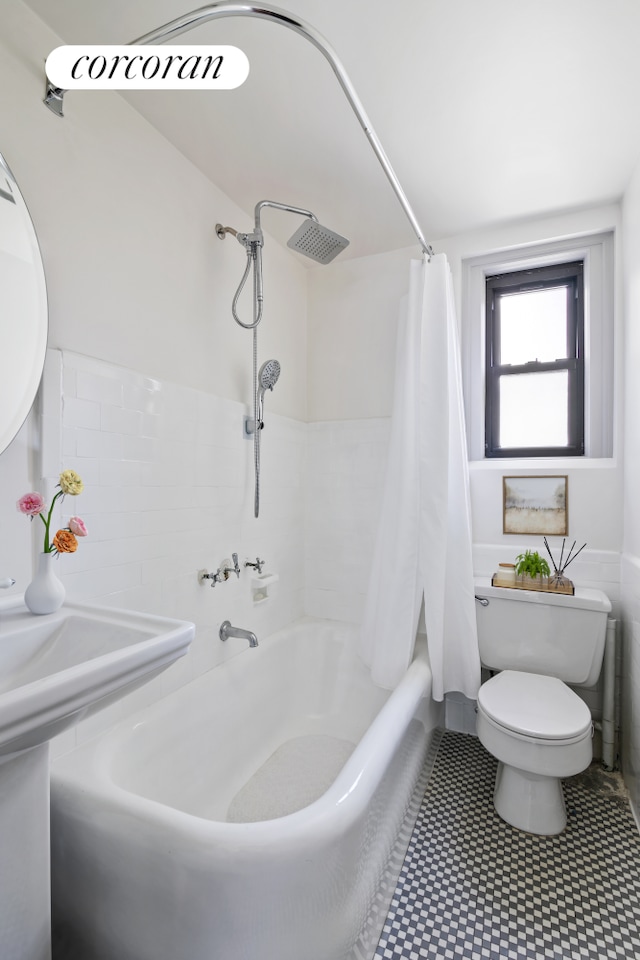 bathroom with tile patterned floors, shower / bathtub combination with curtain, and toilet