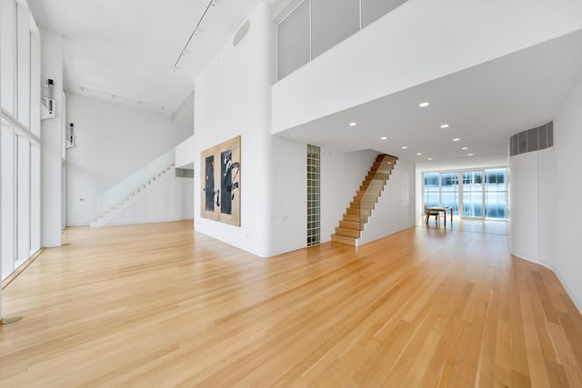 unfurnished living room featuring light hardwood / wood-style flooring and track lighting