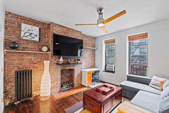 living room with radiator, cooling unit, ceiling fan, wood-type flooring, and a fireplace