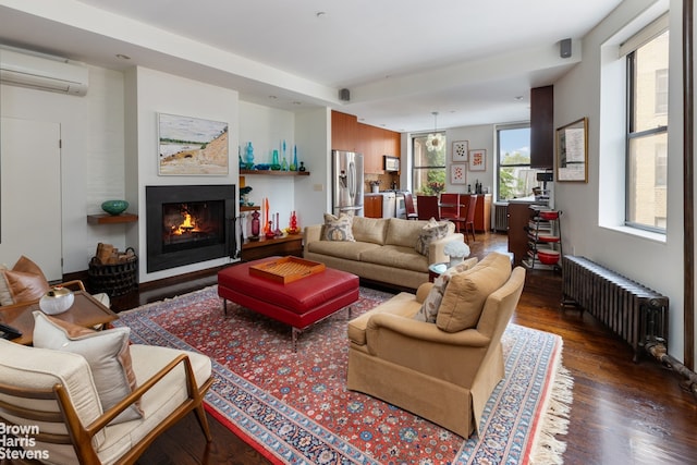 living room featuring a wall mounted air conditioner, dark hardwood / wood-style floors, and radiator