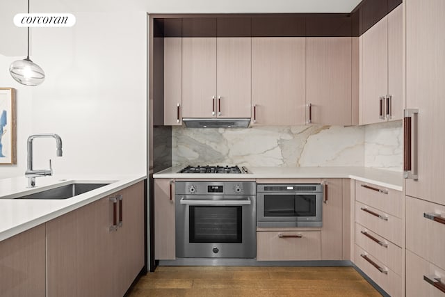 kitchen with pendant lighting, dark wood-type flooring, sink, range hood, and appliances with stainless steel finishes