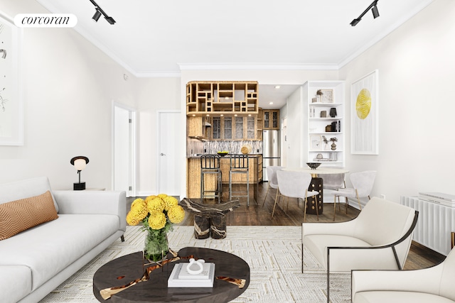 living room with radiator heating unit, crown molding, rail lighting, and wood-type flooring