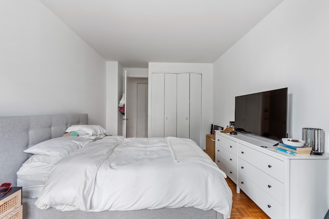 bedroom featuring light parquet floors and a closet