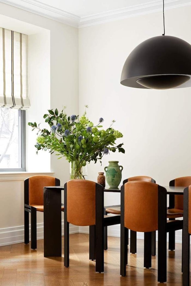 dining room with wood-type flooring and ornamental molding