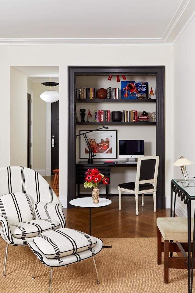 living area with hardwood / wood-style flooring and ornamental molding