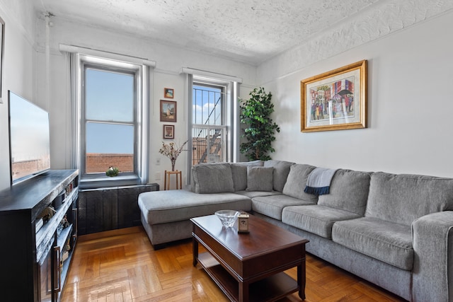 living room featuring a textured ceiling and light parquet floors