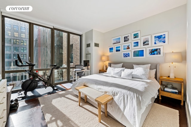 bedroom with a wall of windows and wood-type flooring