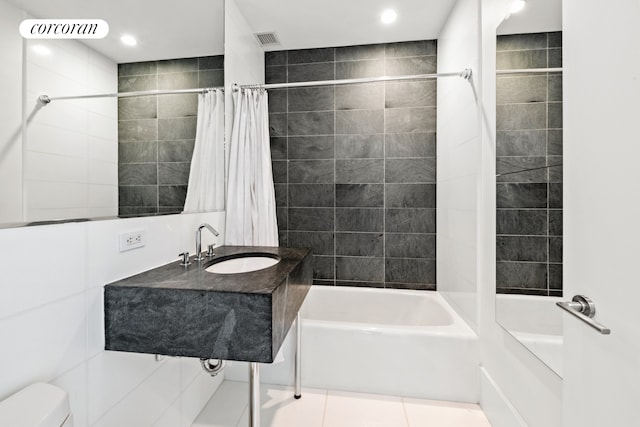 full bathroom featuring tile walls, sink, tile patterned floors, shower / bath combo with shower curtain, and toilet