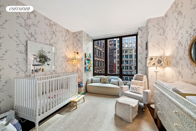 carpeted bedroom with expansive windows and a nursery area