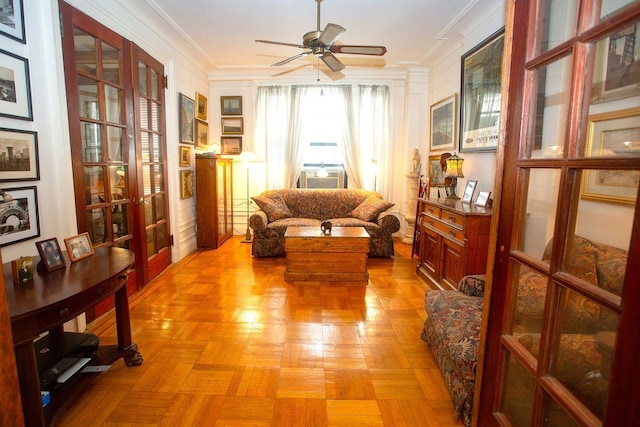 sitting room featuring cooling unit, ceiling fan, light parquet flooring, and ornamental molding