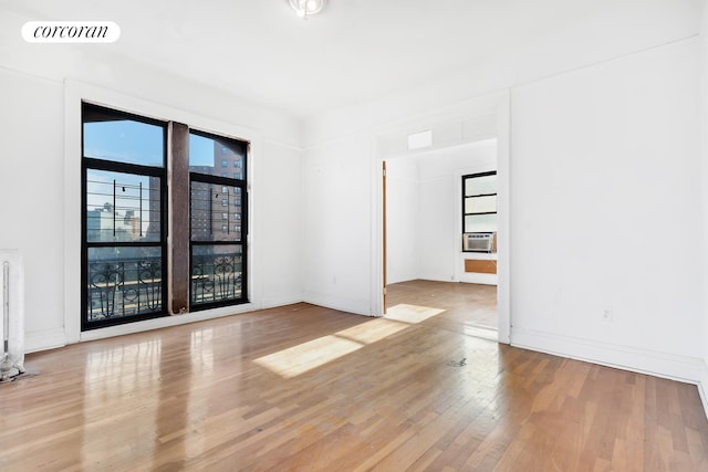 spare room with light hardwood / wood-style floors and cooling unit