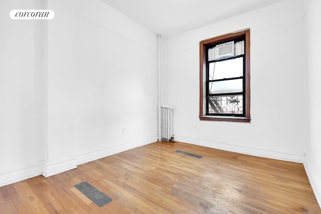 spare room with radiator and wood-type flooring