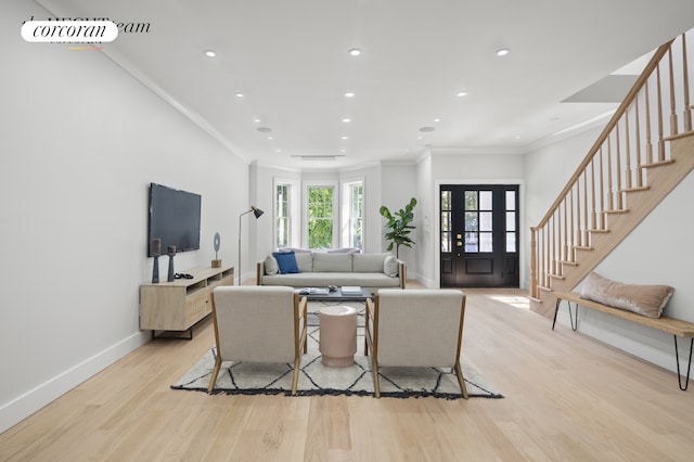 living room with ornamental molding, french doors, and light hardwood / wood-style floors