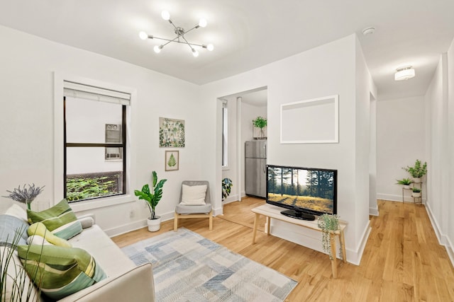 living room with hardwood / wood-style floors and an inviting chandelier