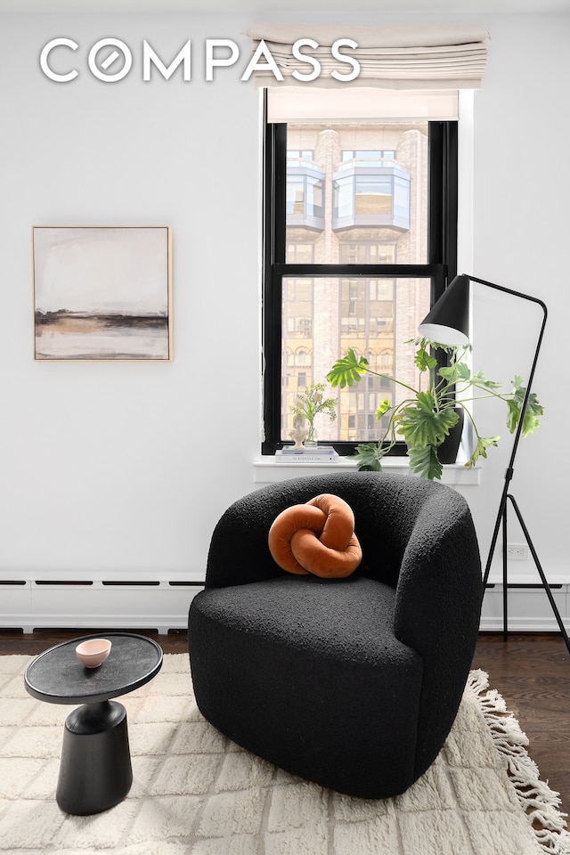 sitting room featuring hardwood / wood-style floors and a baseboard heating unit