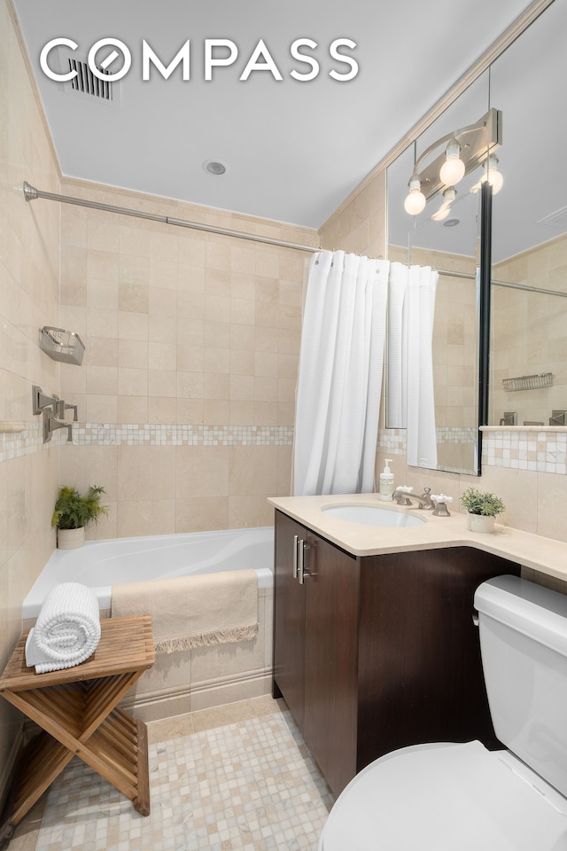 full bathroom with vanity, tile walls, and shower / tub combo