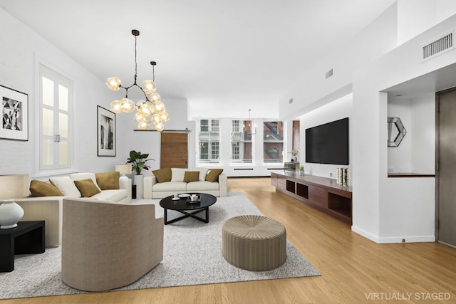 living room featuring a chandelier and light wood-type flooring