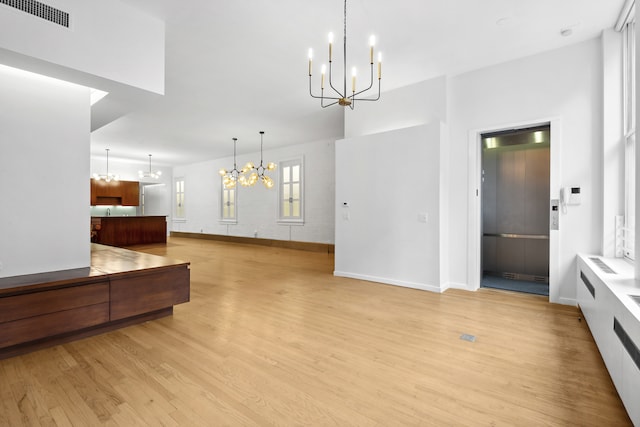 interior space featuring light hardwood / wood-style floors, hanging light fixtures, and a chandelier