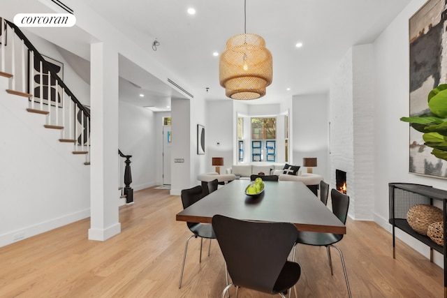 dining room with a fireplace and light hardwood / wood-style flooring