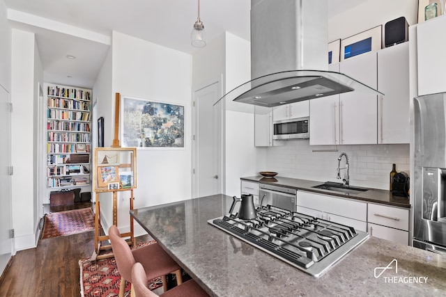 kitchen with island exhaust hood, sink, dark wood-type flooring, appliances with stainless steel finishes, and white cabinets