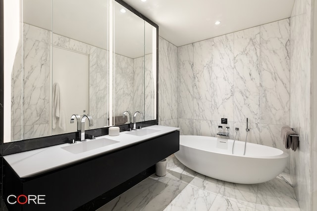 bathroom featuring tile walls, vanity, and a tub