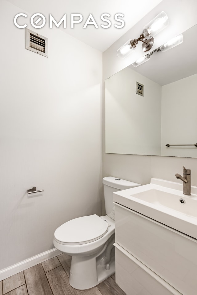 bathroom featuring hardwood / wood-style floors, vanity, and toilet