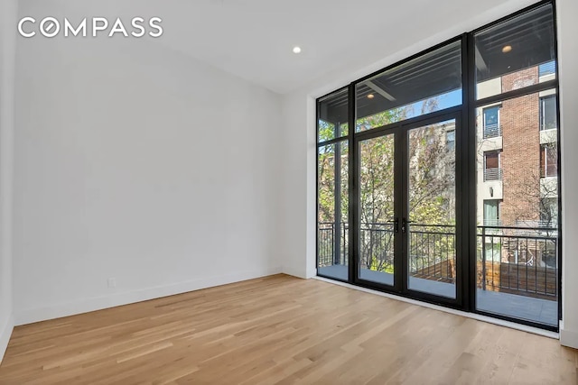 interior space featuring floor to ceiling windows and light hardwood / wood-style floors