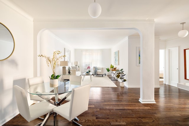 dining space featuring ornamental molding and dark hardwood / wood-style flooring