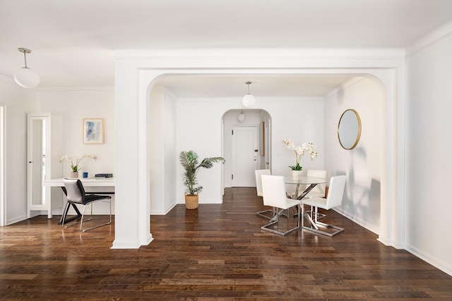 dining area with ornamental molding and dark hardwood / wood-style floors