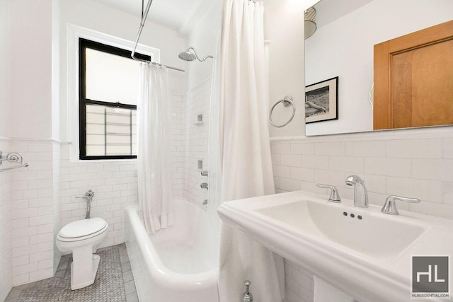 full bathroom featuring tile patterned floors, tile walls, and sink