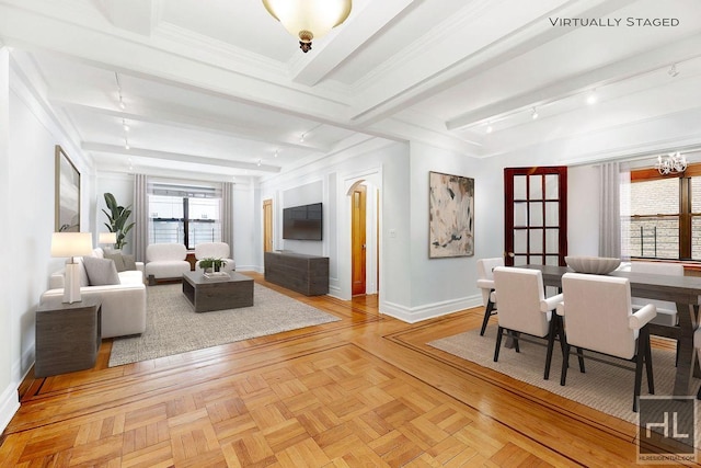 living room featuring a notable chandelier, light parquet flooring, crown molding, and track lighting