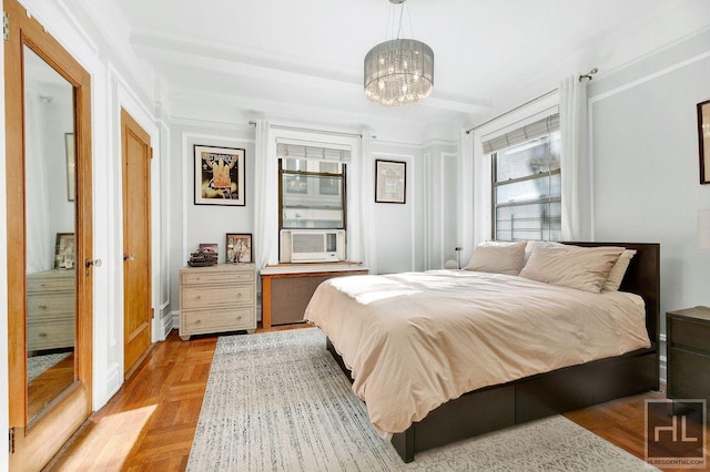 bedroom with light parquet flooring, an inviting chandelier, and cooling unit