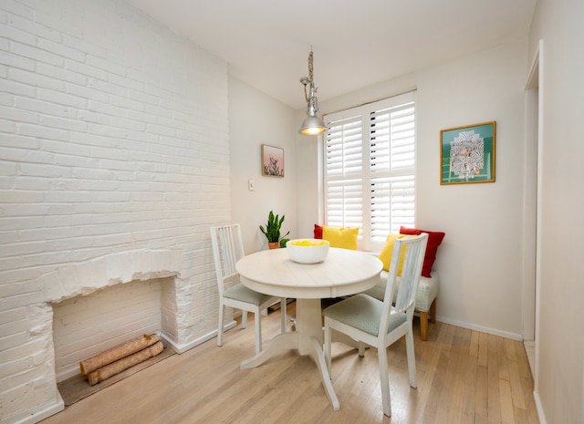 dining room with a fireplace and light hardwood / wood-style floors